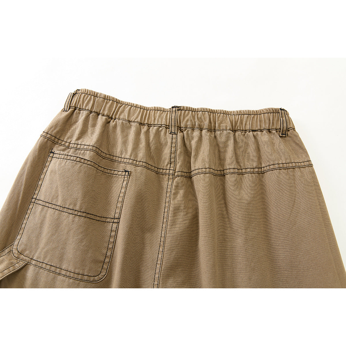 Close-up of the tan pants' back elastic waistband, contrast stitching, and large patch pocket.