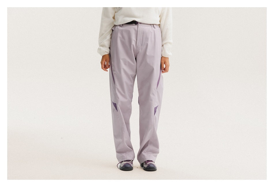 Front view of a person wearing pale lavender pants with purple pocket zippers and knee accents.