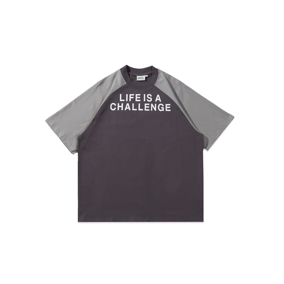 Purple-gray raglan T-shirt with light gray sleeves and white LIFE IS A CHALLENGE chest print, flat lay