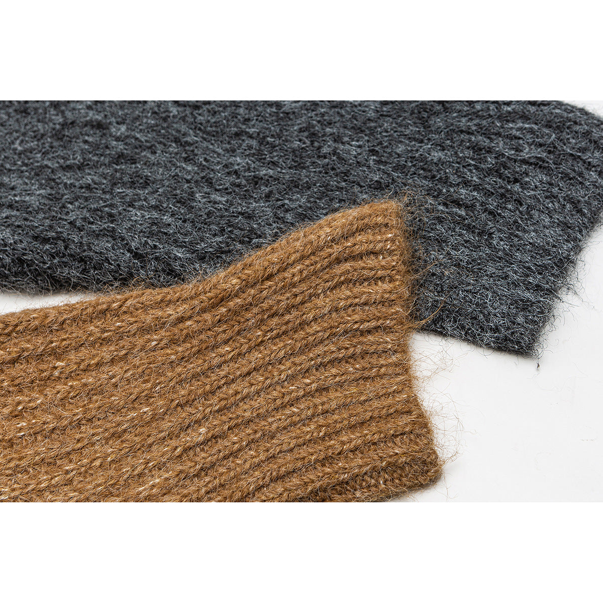 Close-up of charcoal and camel-brown knitted fabric pieces, highlighting their fuzzy texture and stitching.