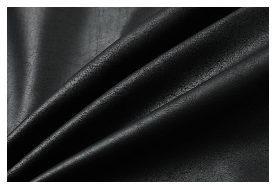 Close-up of the black jacket’s textured material folded into soft diagonal ridges.