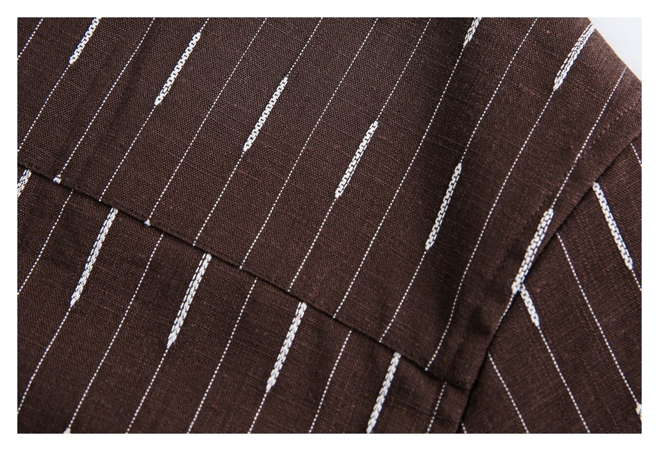 Close-up of dark brown fabric with thin white vertical stripes and occasional thicker broken stripe accents.