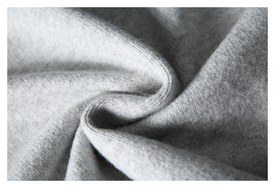 Close-up of the light gray sweater's soft-looking knit stitches and folded fabric.