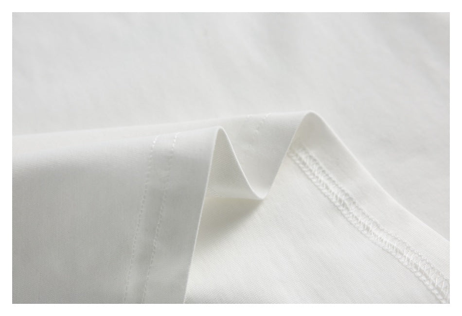 Close-up showing stitched seams and overlocked edge on white T-shirt fabric.