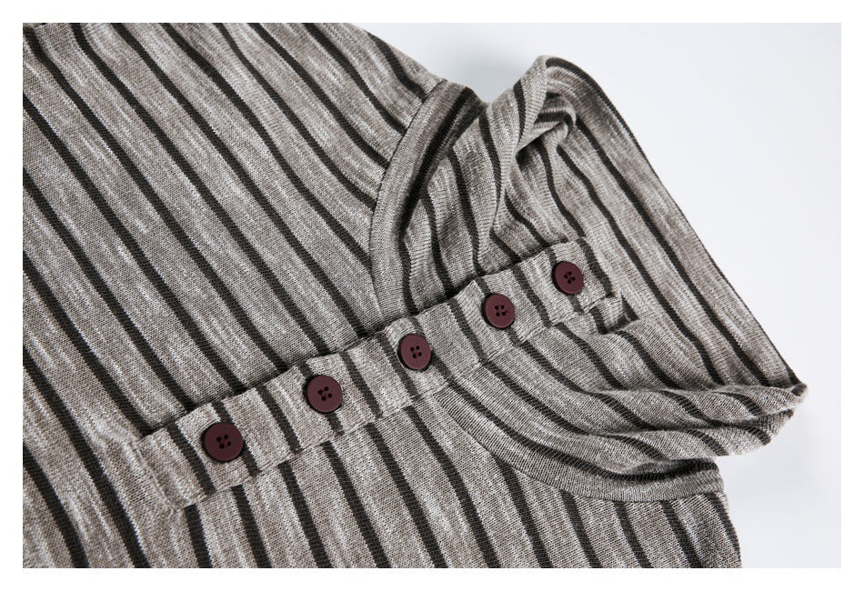 Close-up of the striped top's sleeve cuff, showing a buttoned tab with five dark burgundy buttons.