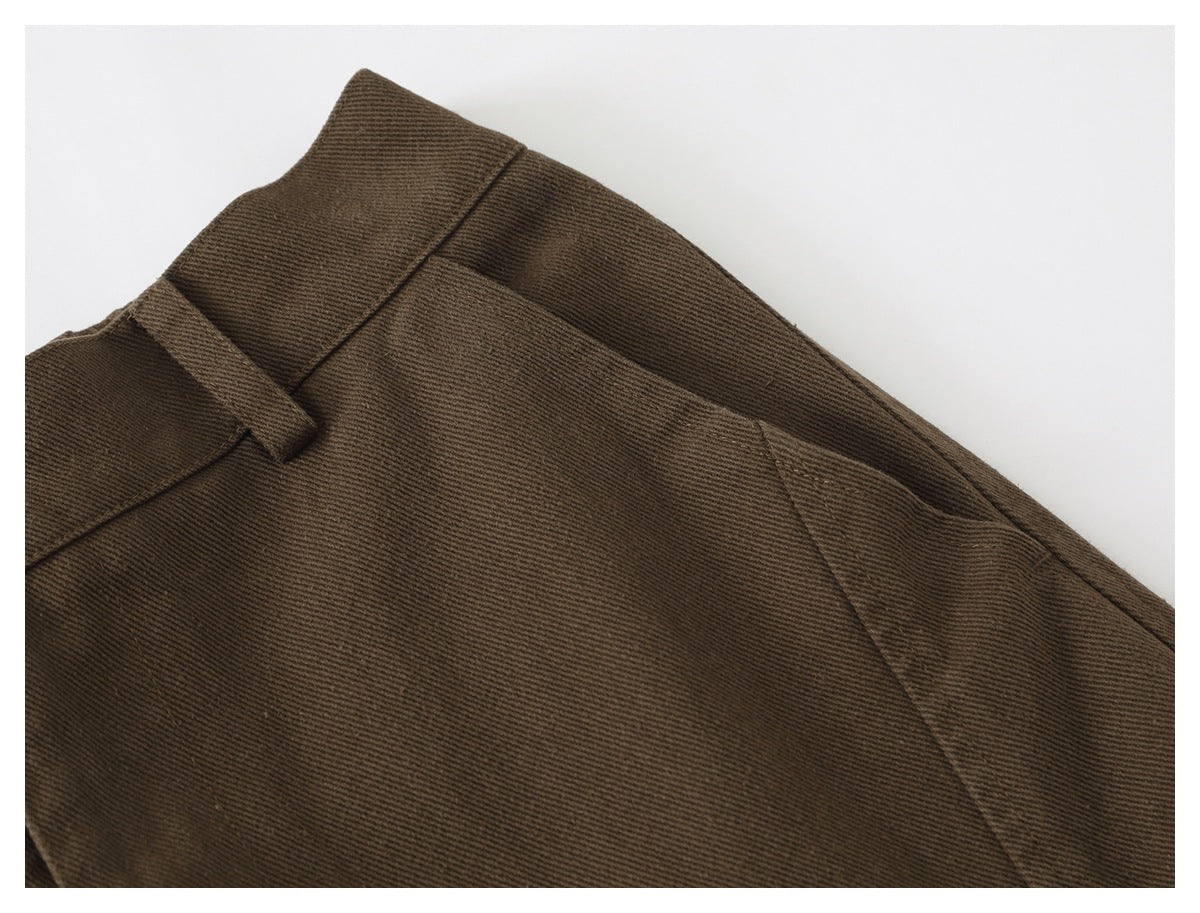 Close-up of a brown trouser front pocket, waistband and belt loop.