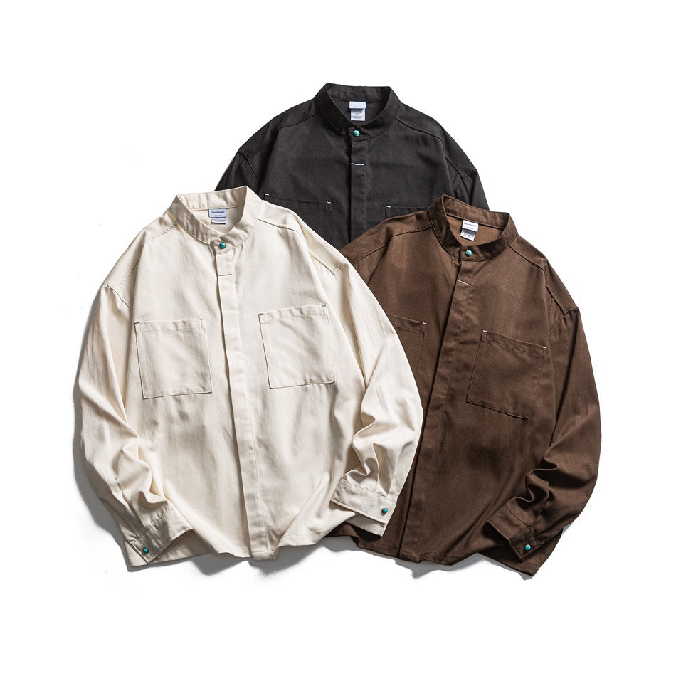Three long-sleeve stand-collar shirts with chest pockets, shown in cream, brown, and black.