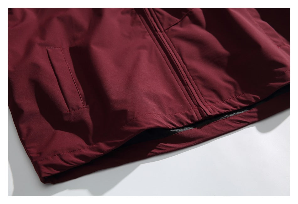 Close-up of the burgundy jacket's lower front, showing a pocket opening, zipper and hem.