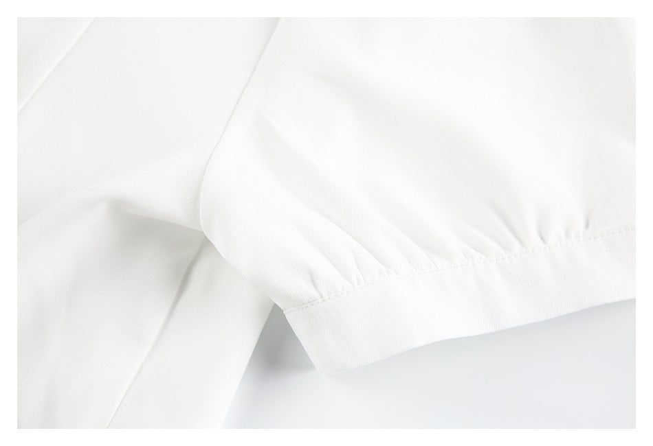Close-up of a white gathered sleeve ending in a wide stitched cuff.