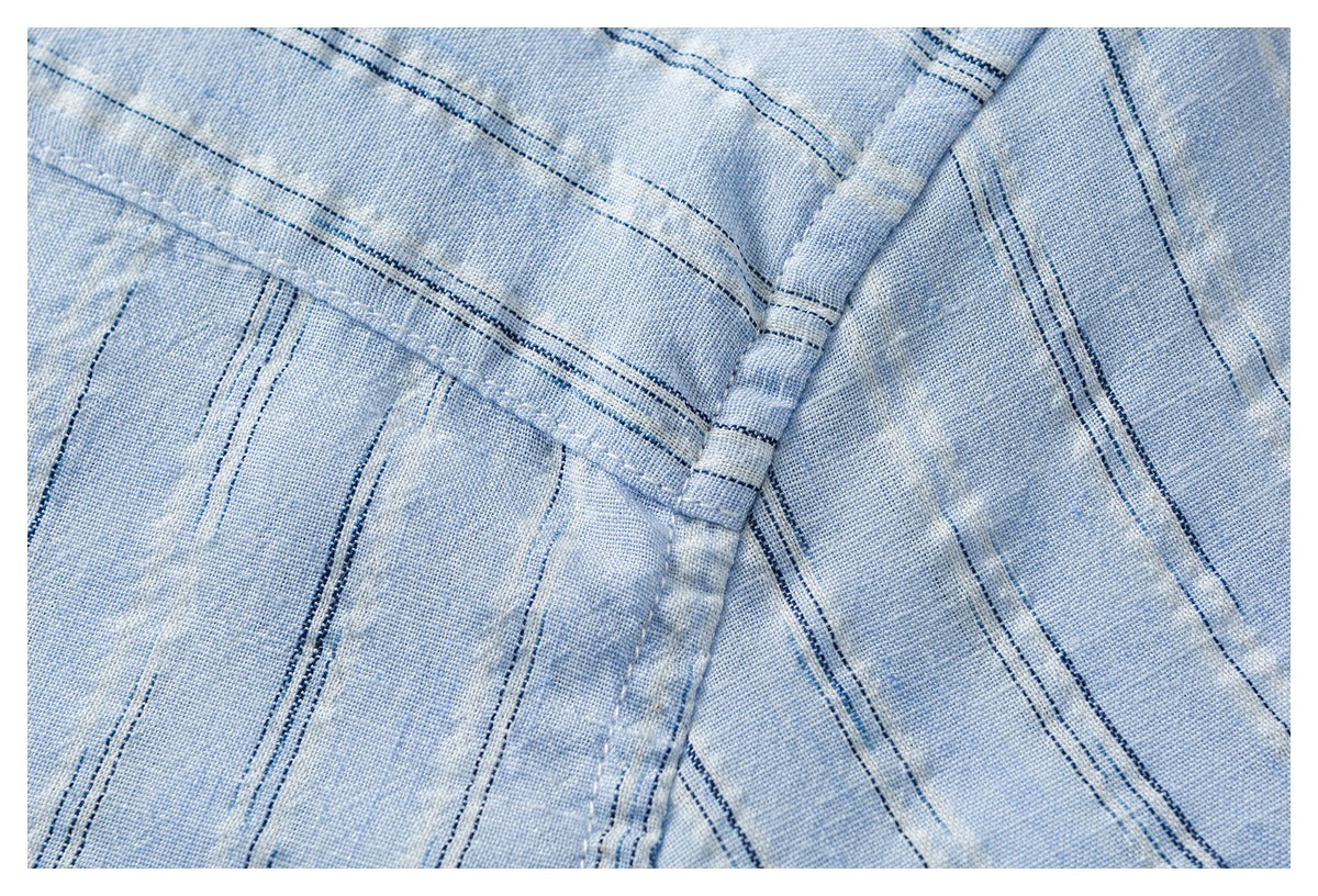 Pale blue striped fabric detail showing intersecting seams and close stitching.