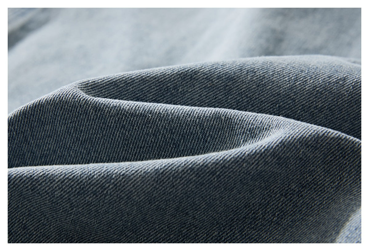 Close-up of dark blue denim showing its diagonal weave and folded texture.