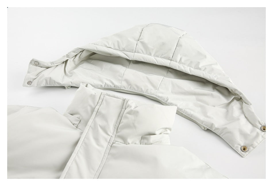 Close-up of an off-white jacket's hood, snap fasteners, and front zipper area.