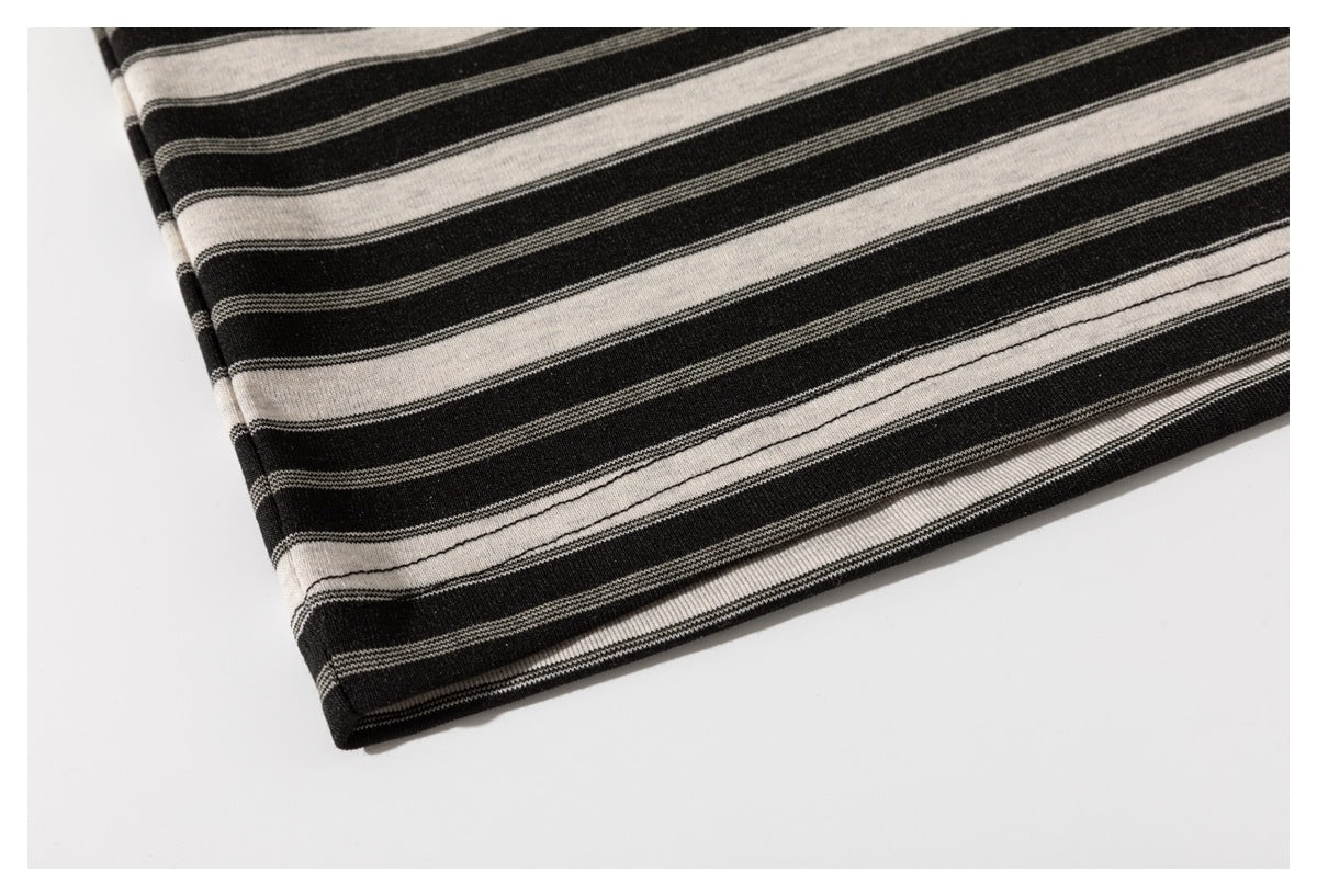 Close-up of the black and cream striped shirt fabric at a folded hem.