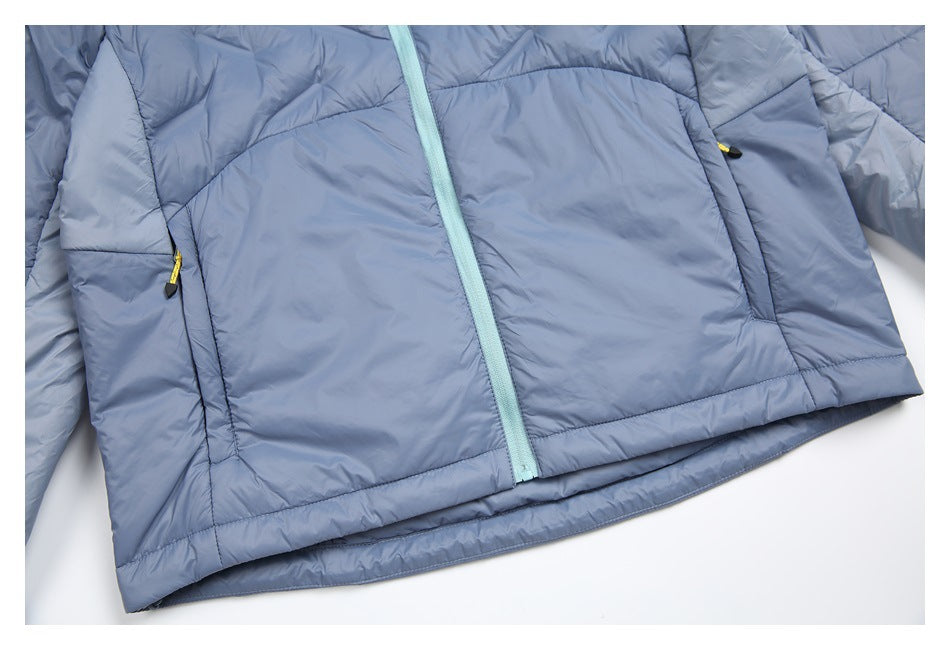 Close-up of the pale blue jacket's front hem, mint zipper, and zippered side pockets.