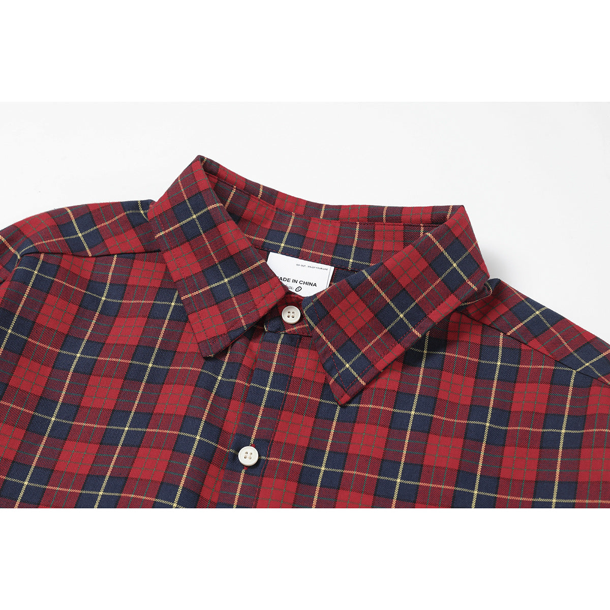 Close-up of a red and navy plaid button-up shirt collar with white buttons and a visible inner label.