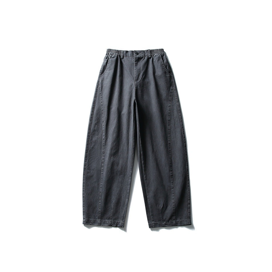 Front view of dark gray wide-leg pants with elastic waistband, button fly and curved leg seams, flat lay