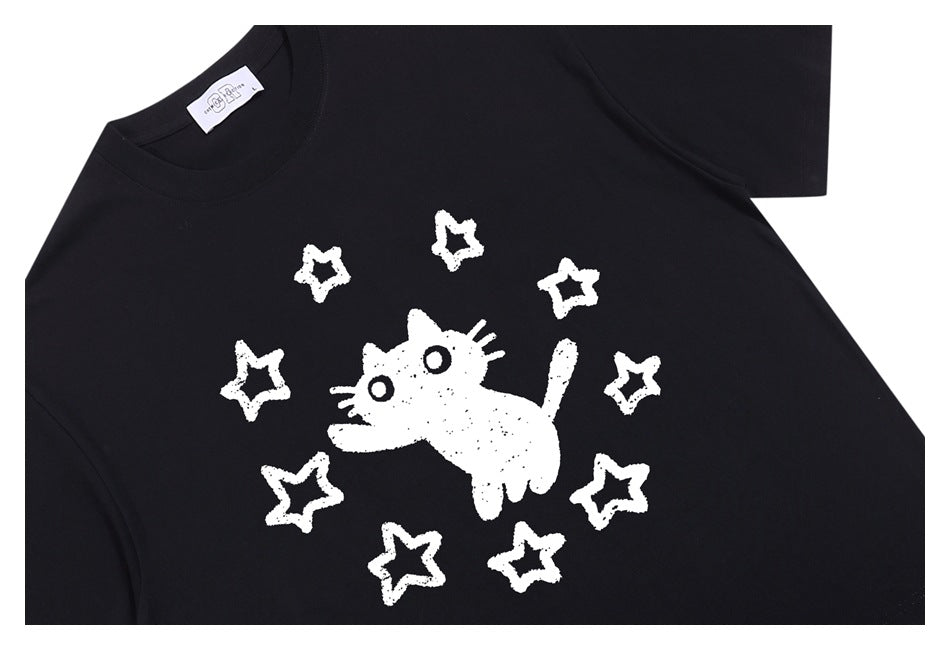 Black short-sleeve T-shirt laid flat, with a white cartoon cat and star graphic on the chest.