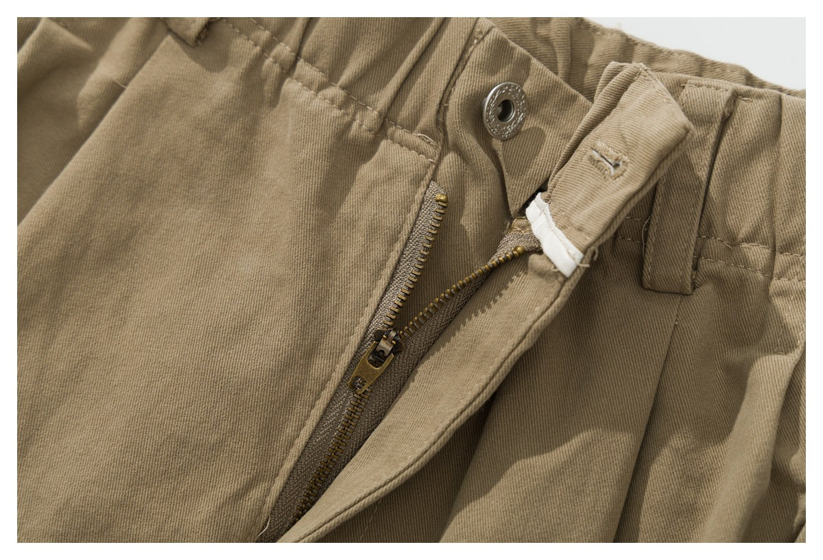 Close-up of the open fly and metal zipper on khaki pants.
