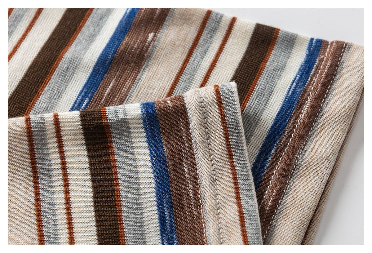 Close-up of the striped shirt fabric and folded, stitched edge in cream, brown, gray, and blue.