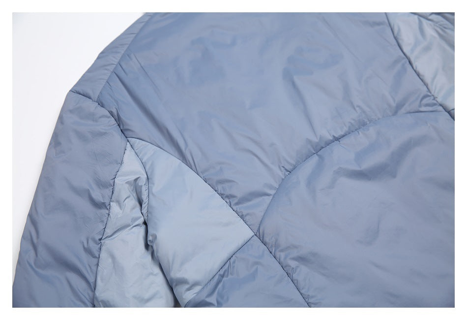 Close-up of blue padded jacket panels and their curved stitched seams.