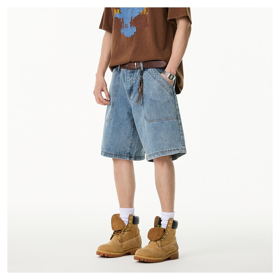 Person wearing light blue denim shorts with large front pockets, a brown graphic T-shirt, white socks and tan boots.