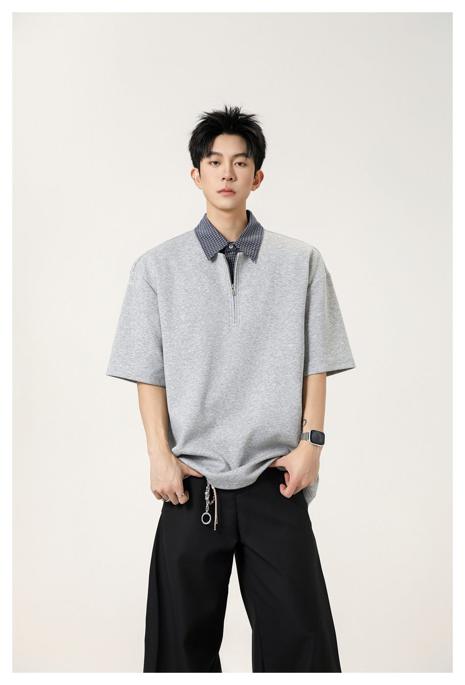 Model wearing a light gray short-sleeve quarter-zip polo with a checked collar.