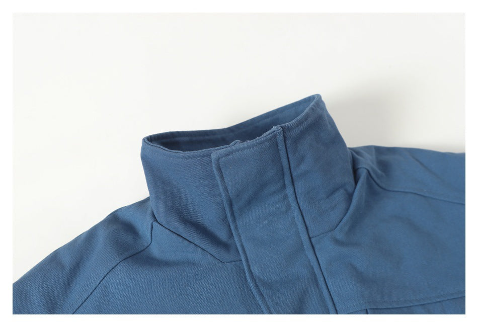 Close-up of a blue jacket's stand collar, shoulder seam, and upper chest.