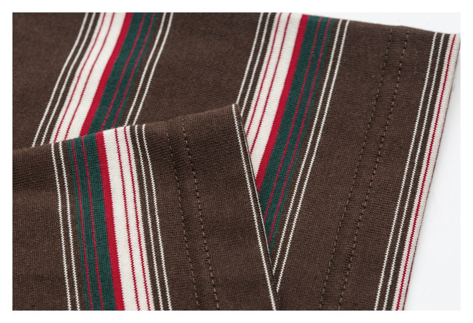 Close-up of the brown knit top's striped sleeve cuff and stitched hem.