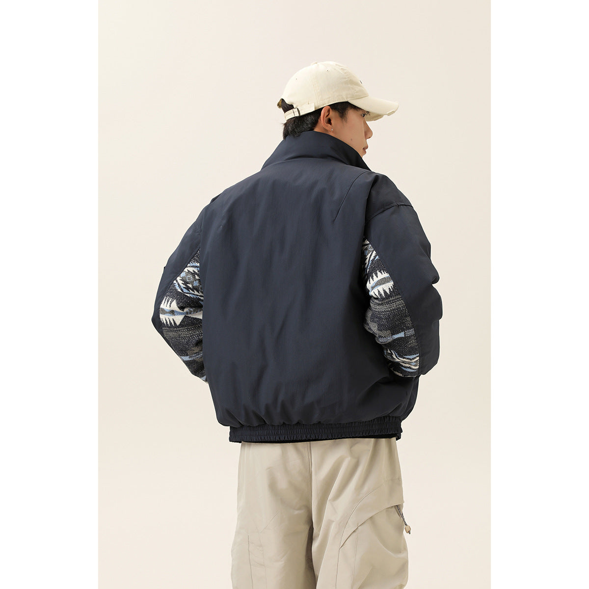 Rear view of a model wearing a dark navy jacket with patterned sleeves visible at the sides.
