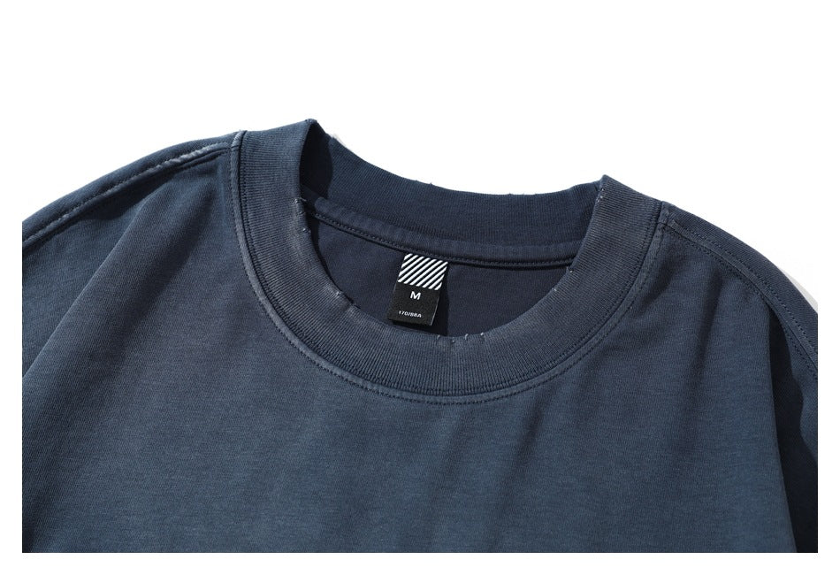 Close-up of a dark navy crew-neck shirt collar with a black size M neck tag.