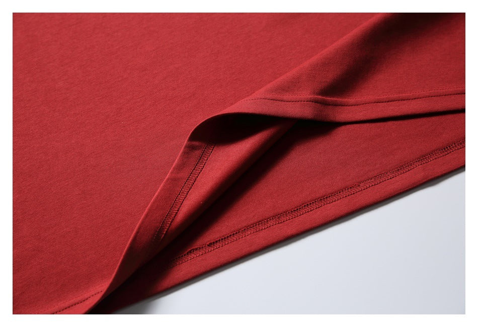 Close-up of the red T-shirt's folded lower hem and stitching.