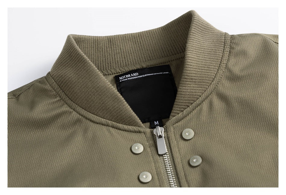 Close-up of an olive jacket’s ribbed collar, zipper, metal snaps and black inner label.