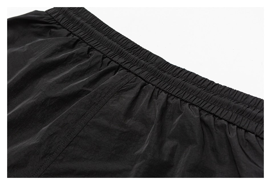 Close-up of a black garment's gathered elastic waistband and stitched seam.
