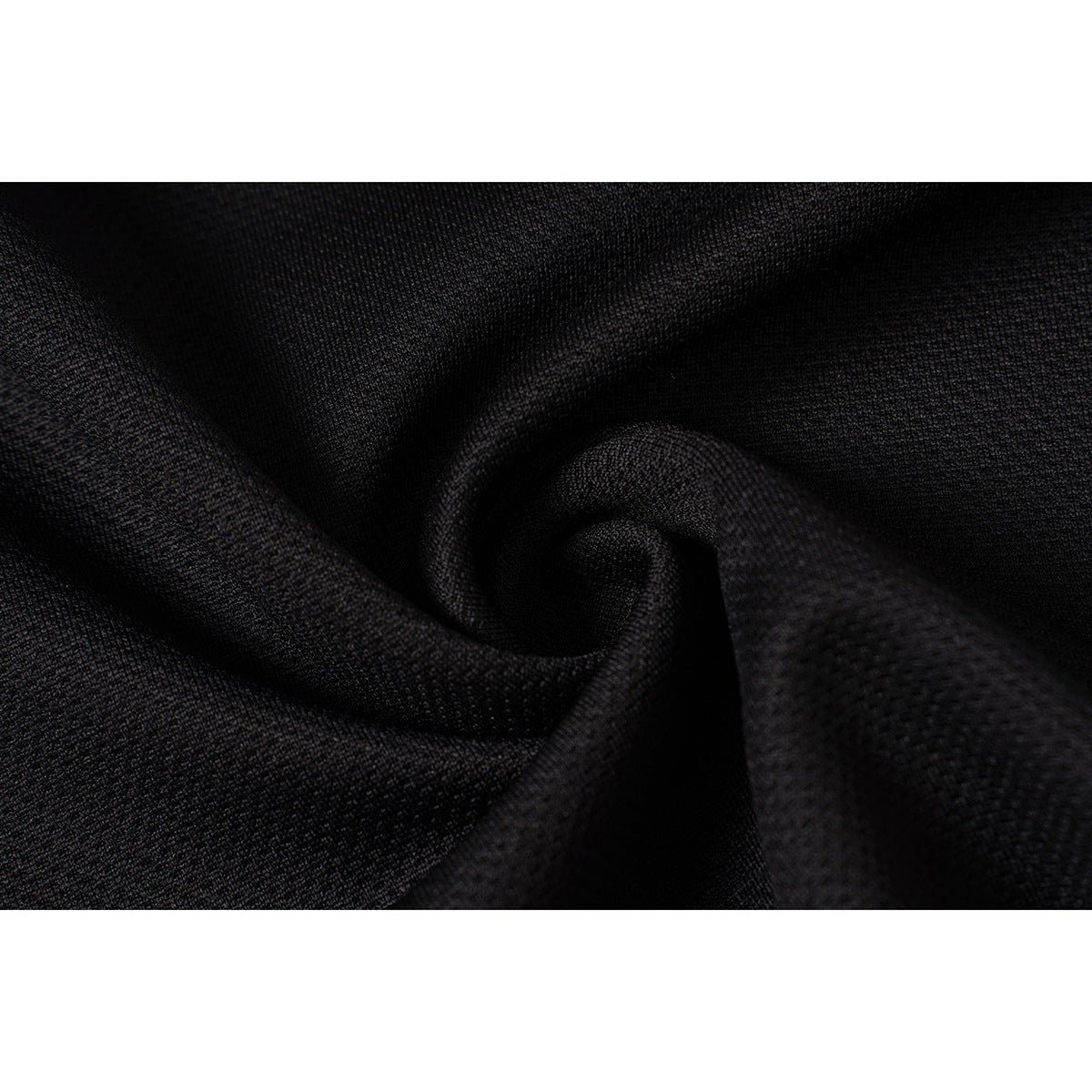 Close-up of the black polo's textured fabric, shown gathered into soft folds.