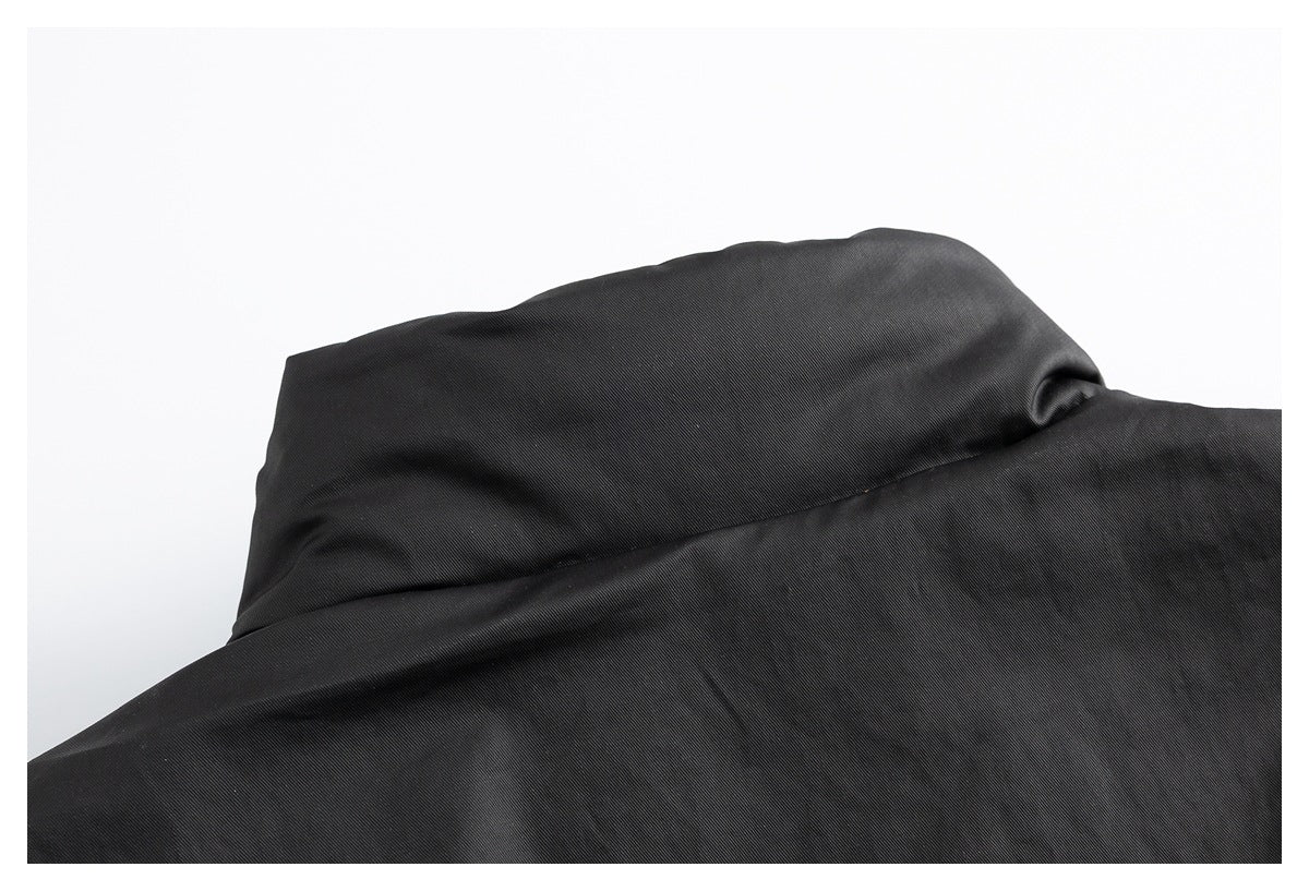 Close-up of a raised folded section and seam on black garment fabric.