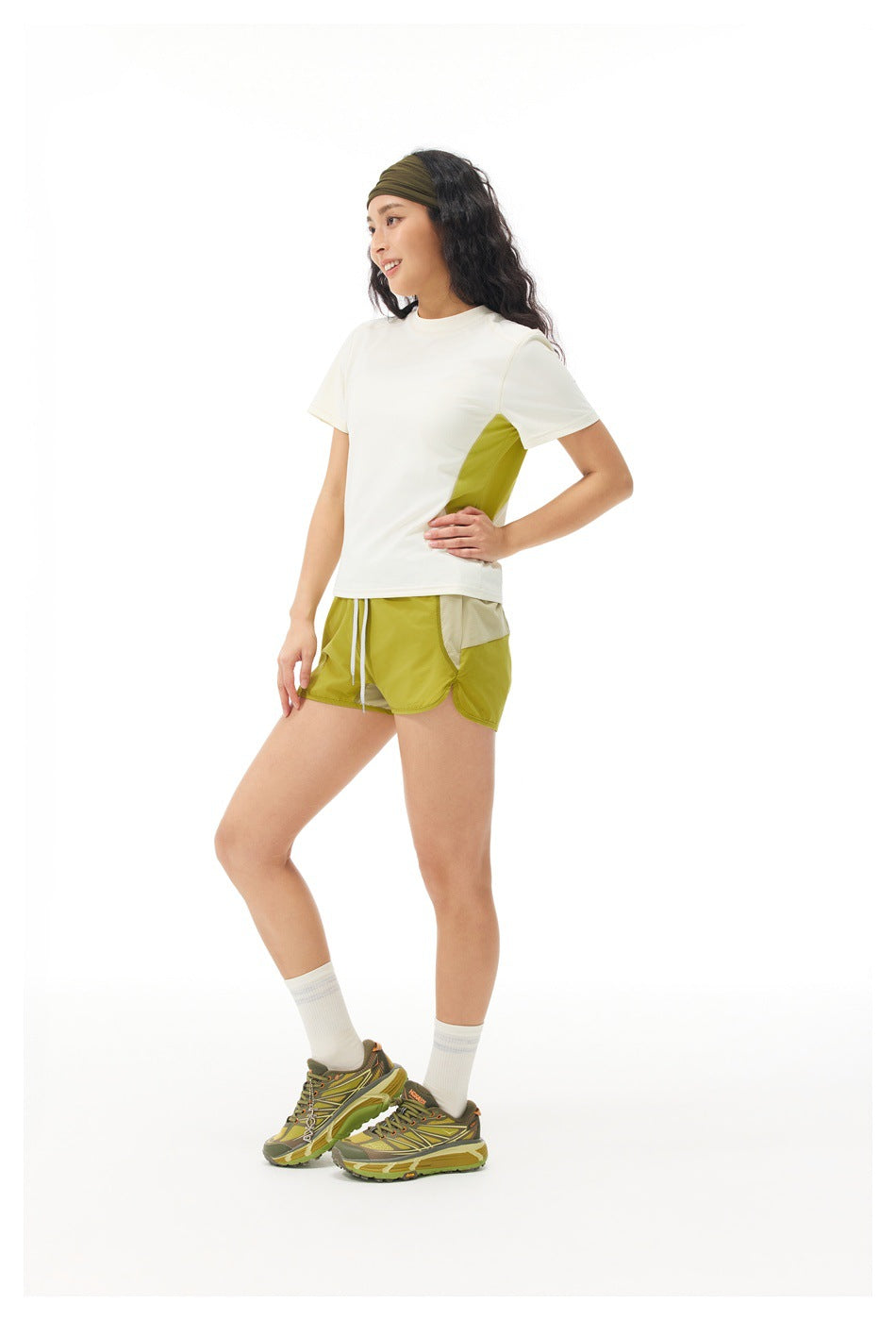 Model in a cream T-shirt with a lime side panel and matching shorts, shown at a three-quarter angle.