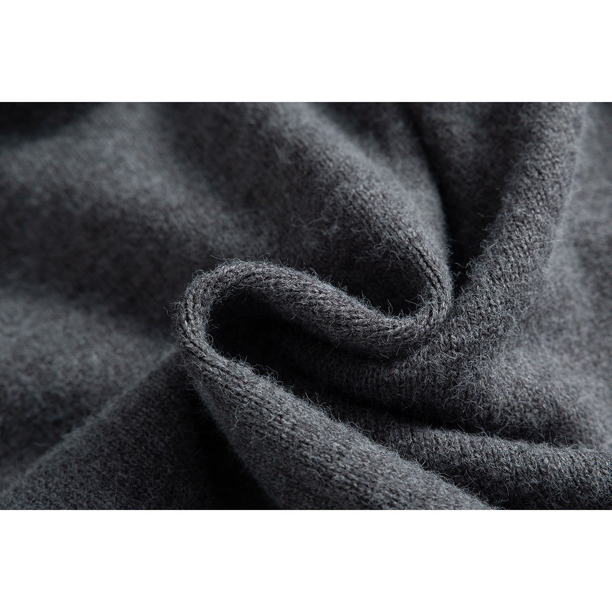 Extreme close-up of the fuzzy knit texture of a charcoal gray garment.