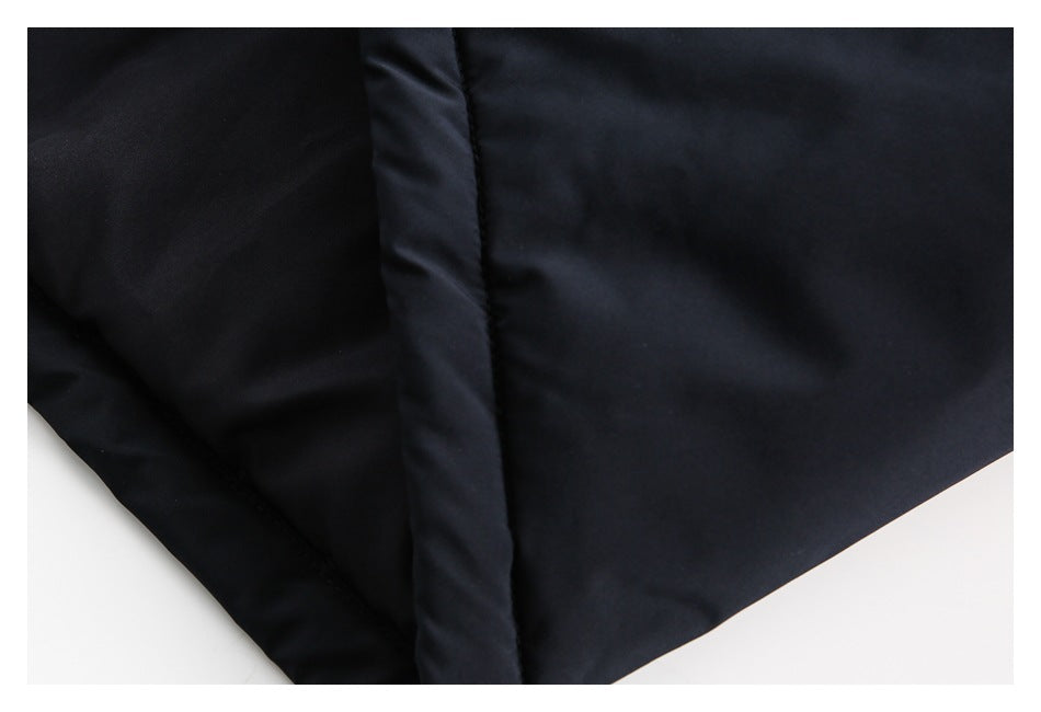 Close-up of the black coat fabric and a vertical stitched seam.