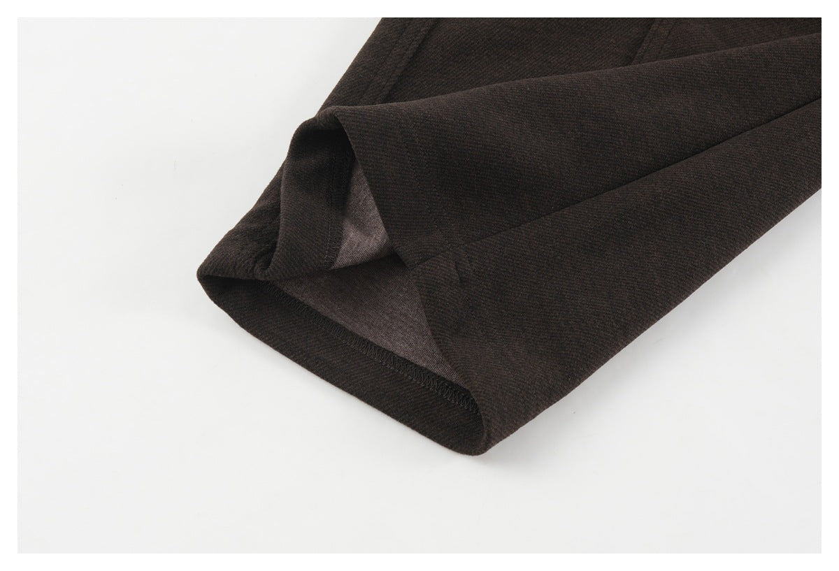 Close-up of a dark brown pant leg hem showing its stitched inner edge.