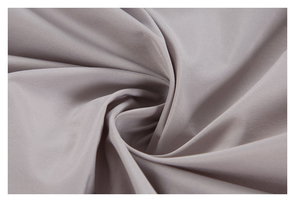 Close-up of light gray jacket fabric gathered into soft folds.