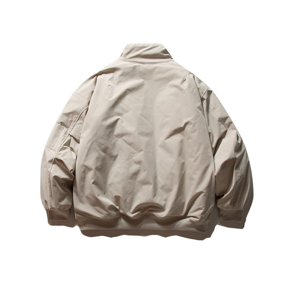 Beige jacket back view, flat lay, showing stand collar, sleeve pocket and ribbed hem and cuffs