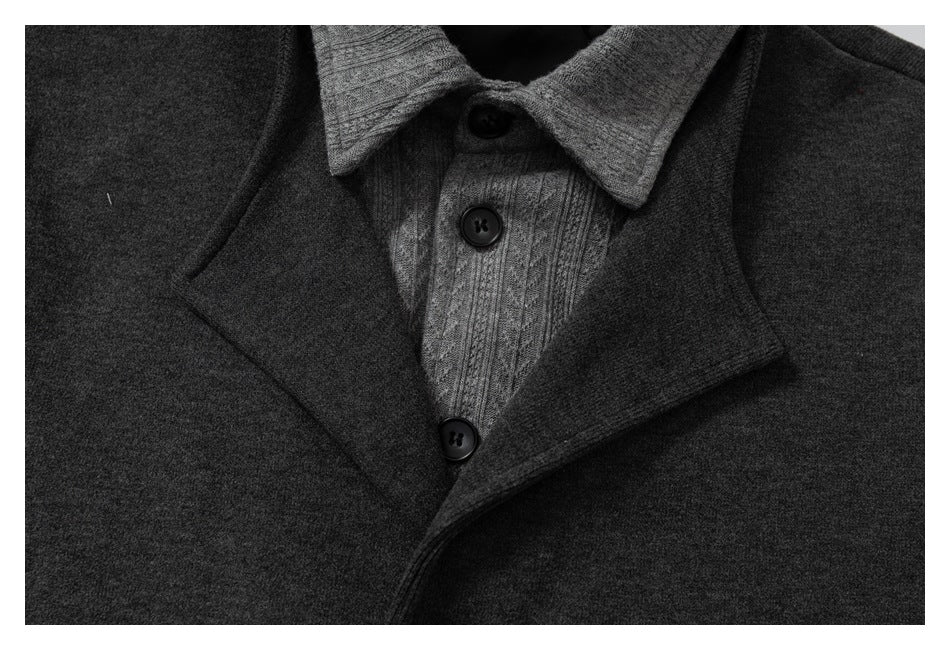 Close-up of a charcoal jacket lapel over a gray cable-knit button-front layer.