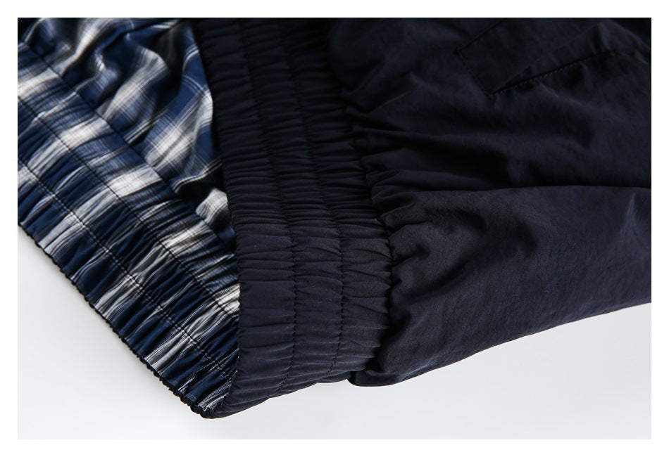 Close-up of the jacket's gathered dark waistband beside blue-and-white plaid lining.