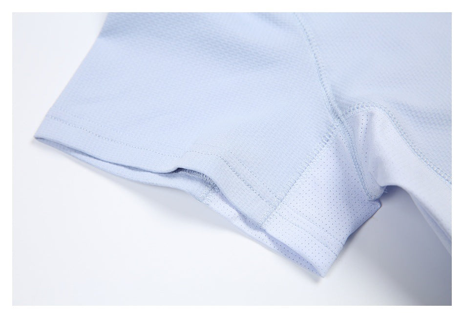 Close-up of a light blue shirt sleeve hem and perforated underarm panel with visible stitching.