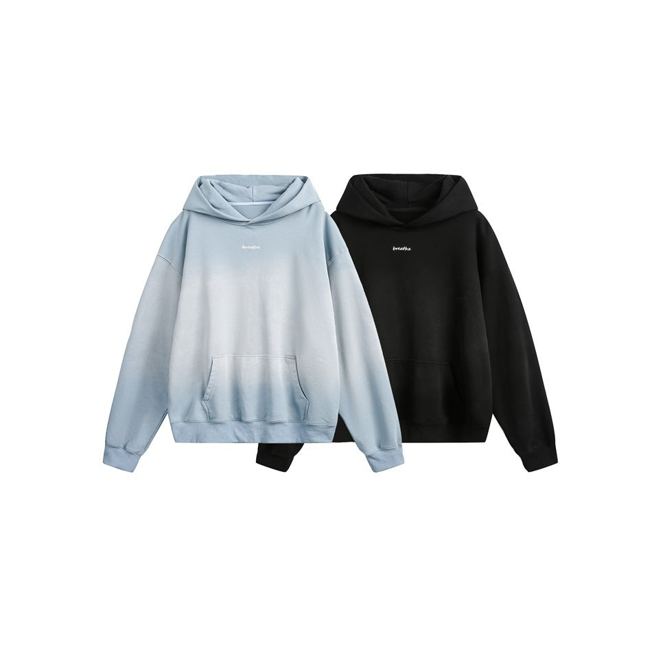 Two front-view hoodies with kangaroo pockets and small chest script, in pale blue and black.