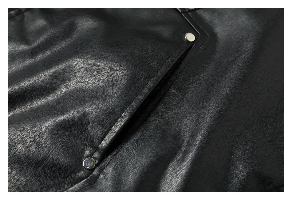 Close-up of a black jacket's diagonal placket with two silver snap buttons.