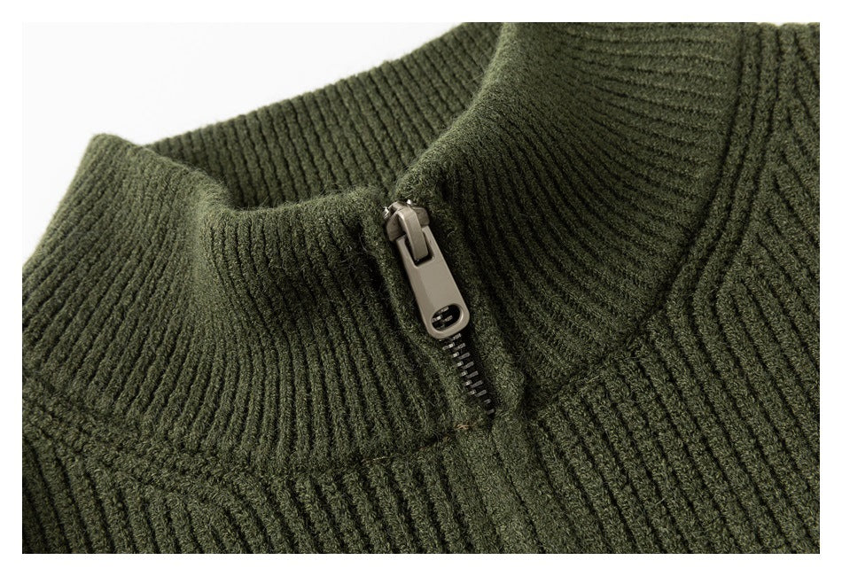 Detailed view of the olive sweater's zipper, high ribbed collar, and knit texture.
