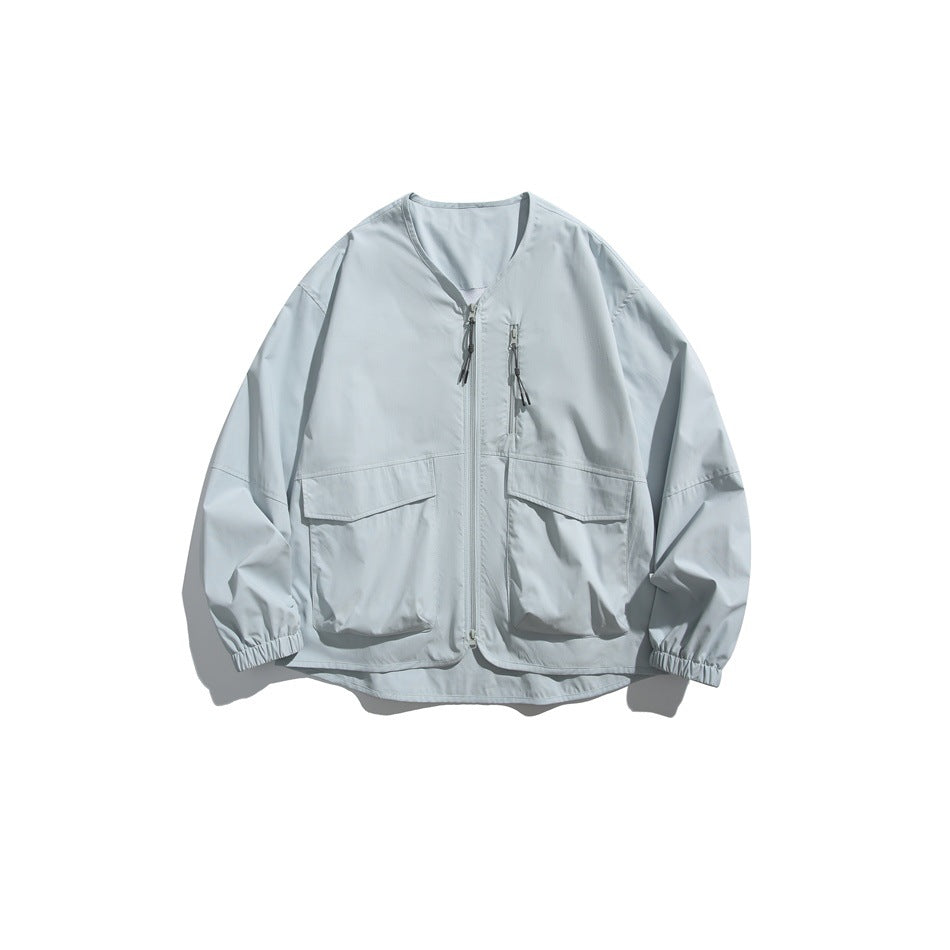 Light blue collarless zip jacket with two large flap pockets and elastic cuffs, flat lay front view