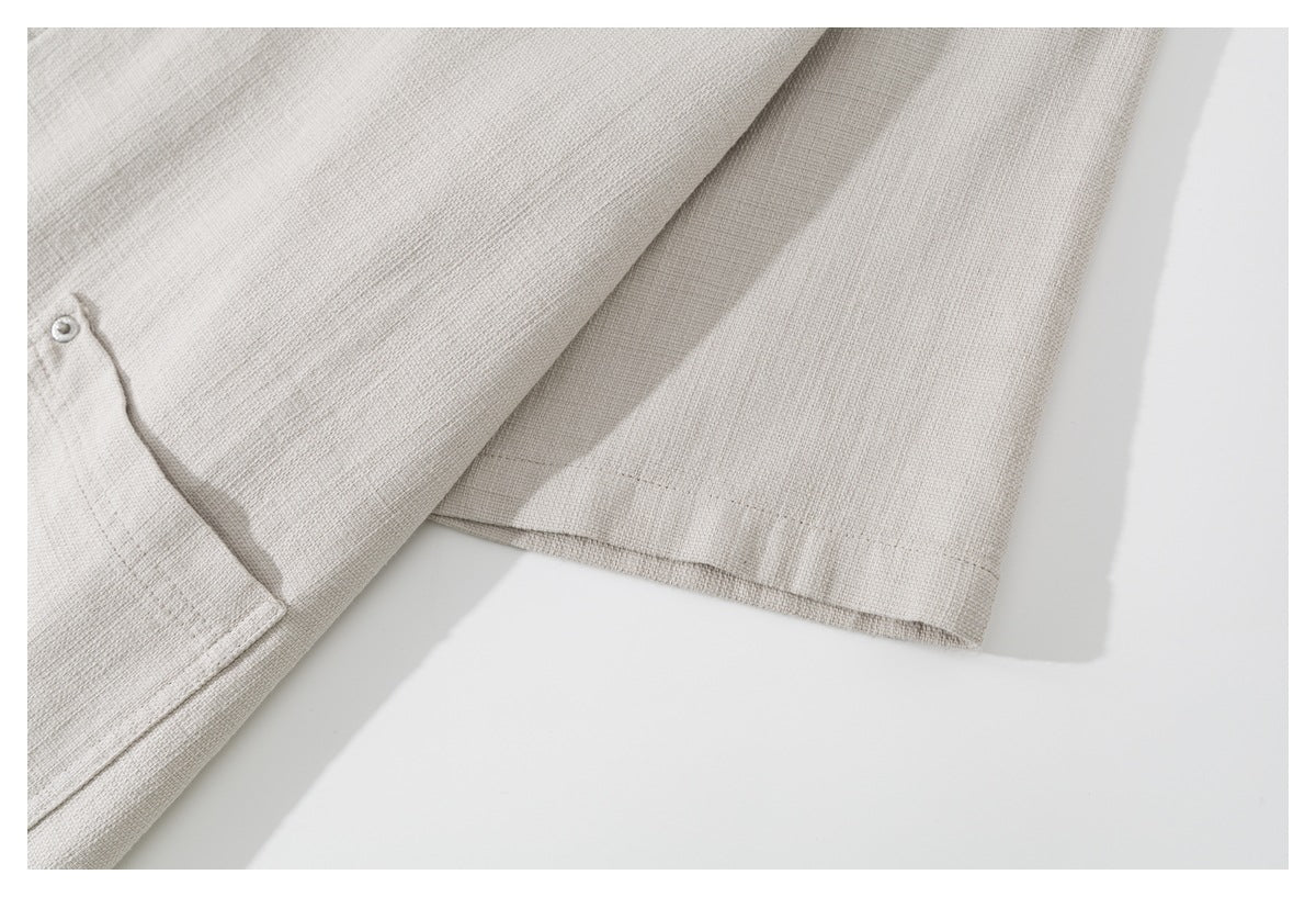 Close-up of the light beige shirt's sleeve and stitched cuff hem.