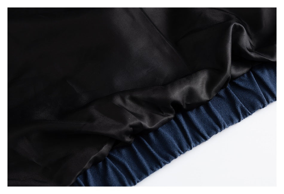 Close-up of smooth black lining beside the gathered navy garment edge.